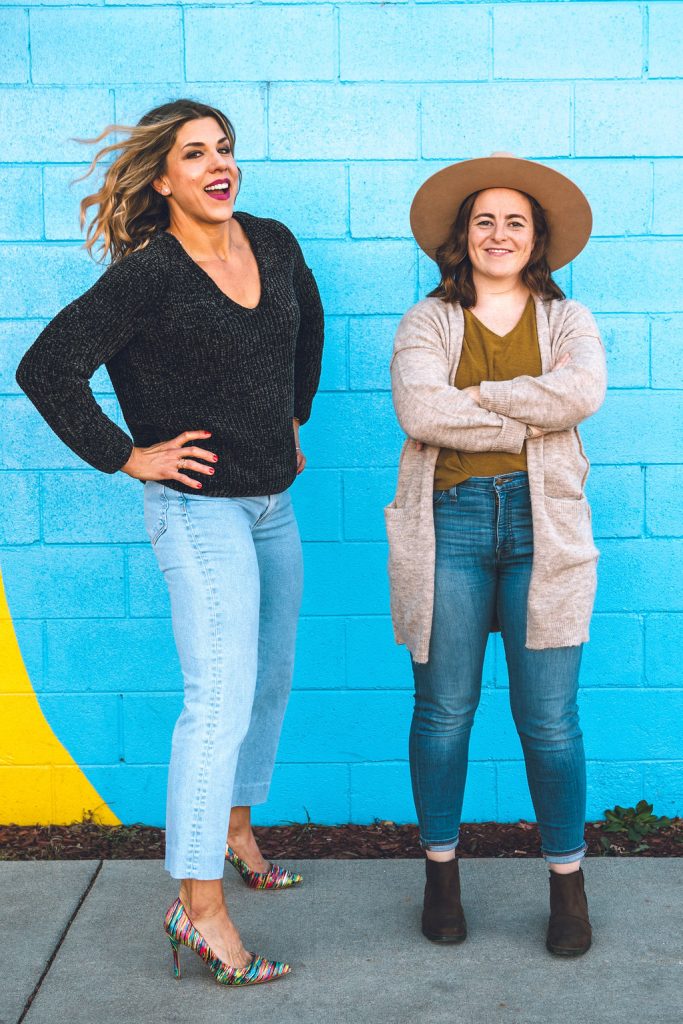 Photo of Joy & Claire against blue brick wall